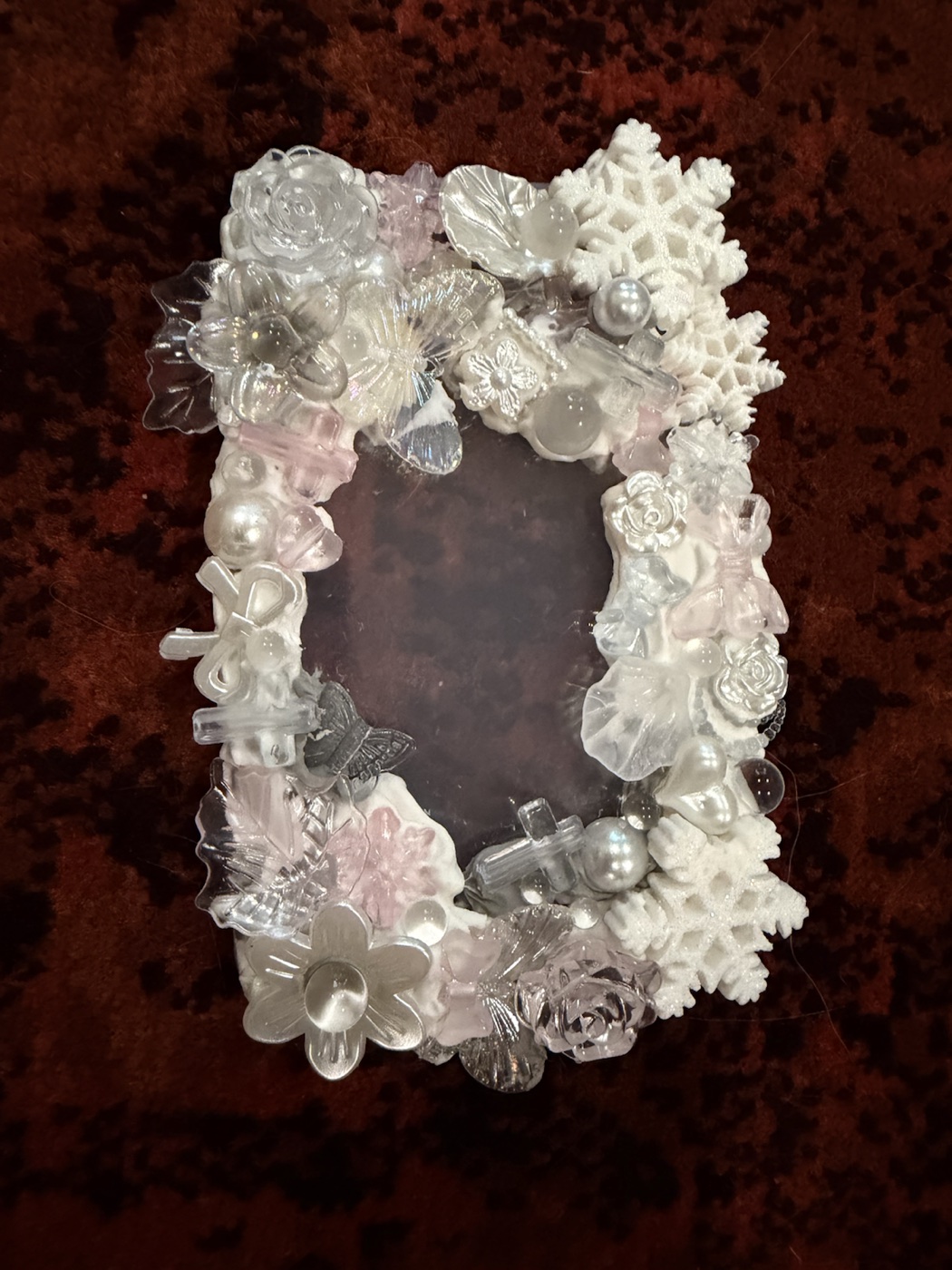 Front view of a clear card case decorated with white cream glue, translucent flowers, butterflies, pearls, bows, and snowflakes.